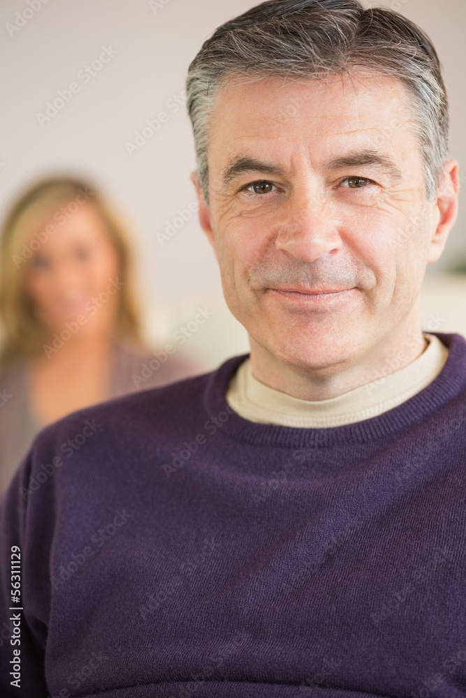 Obraz premium Smiling man with his wife in the background