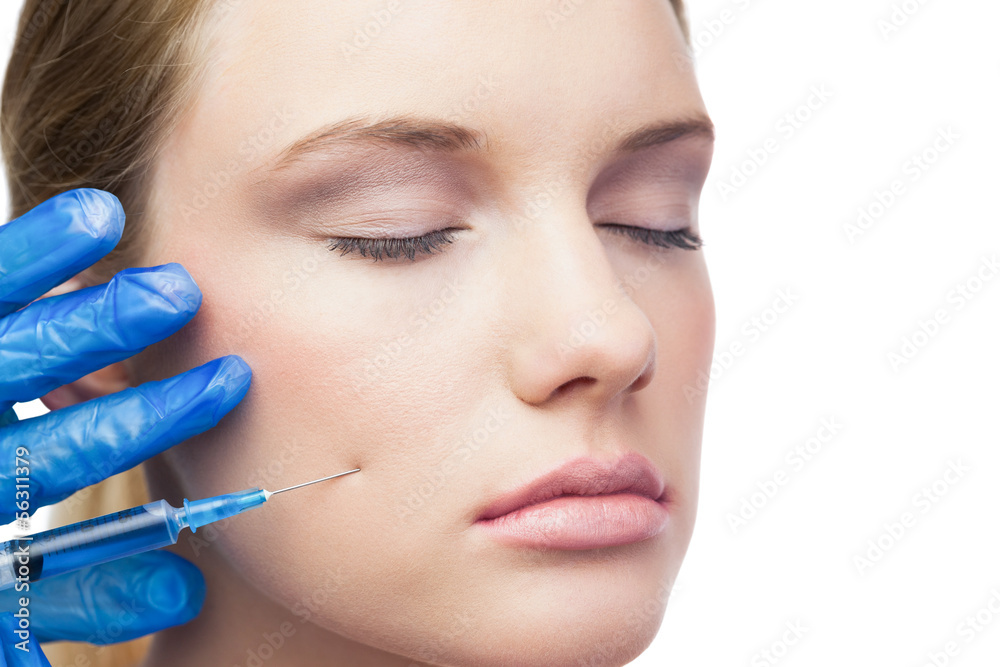 Close-up young woman receives cosmetic injection with syringe