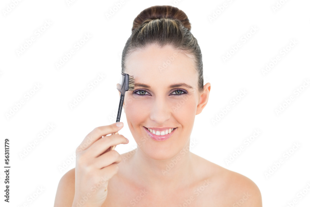 Attractive woman brushing her eyebrow
