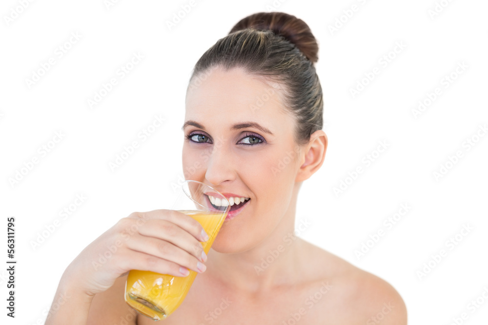 Woman drinking orange juice looking at camera Woman drinking orange juice looking at camera