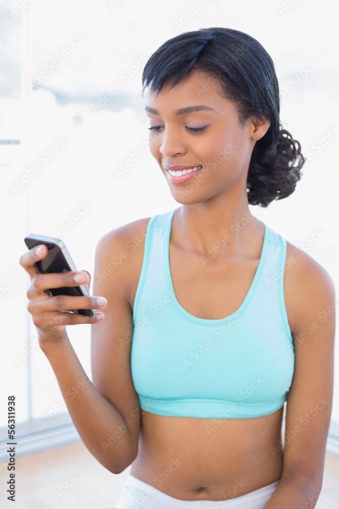 Pleased fit woman texting with her mobile phone Pleased fit woman texting with her mobile phone