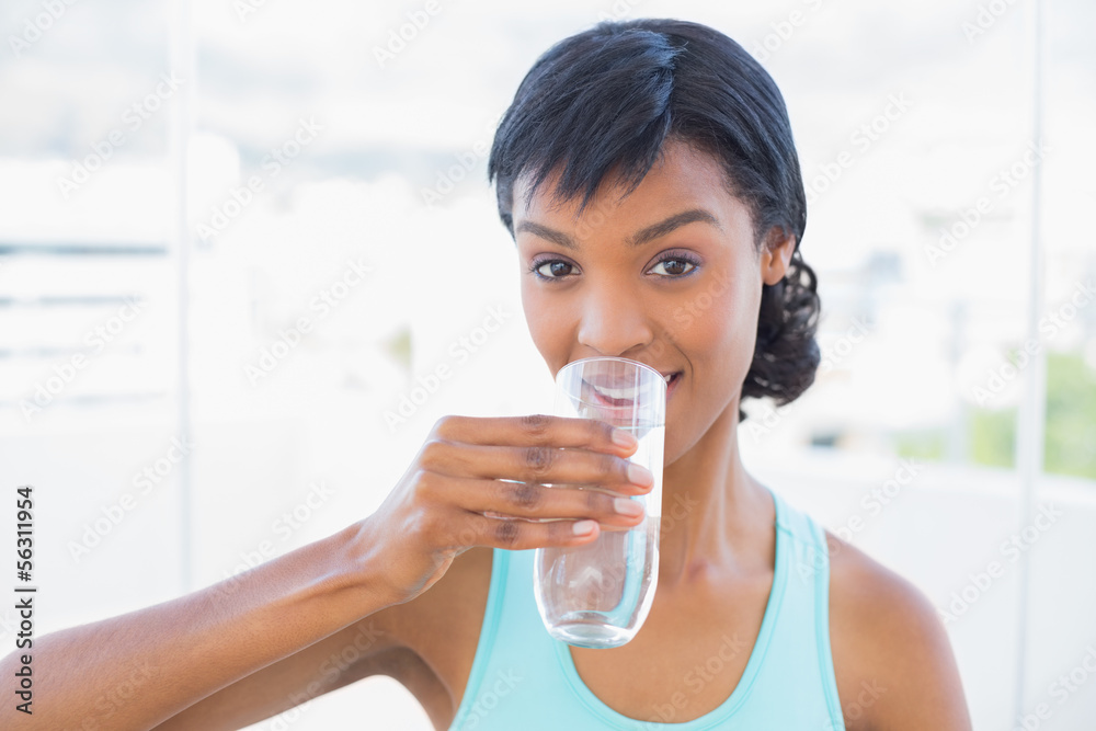 Charming black haired woman drinking a glass of water Charming black haired woman drinking a glass of water