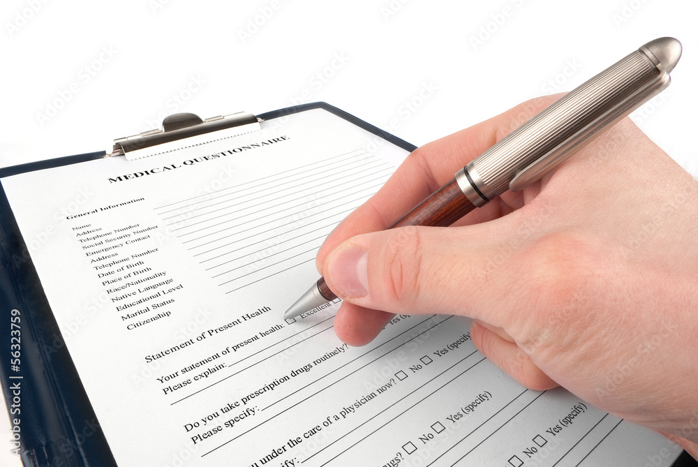 Doctor filling in medical questionnaire form in a clipboard Doctor filling in medical questionnaire form in a clipboard
