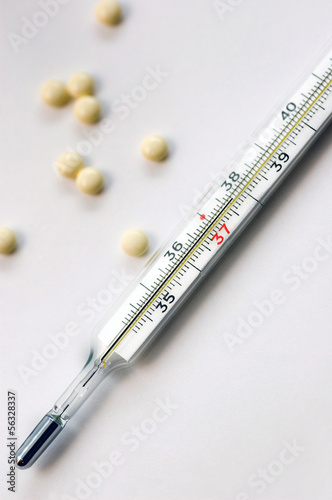 Medical thermometer and pills photo