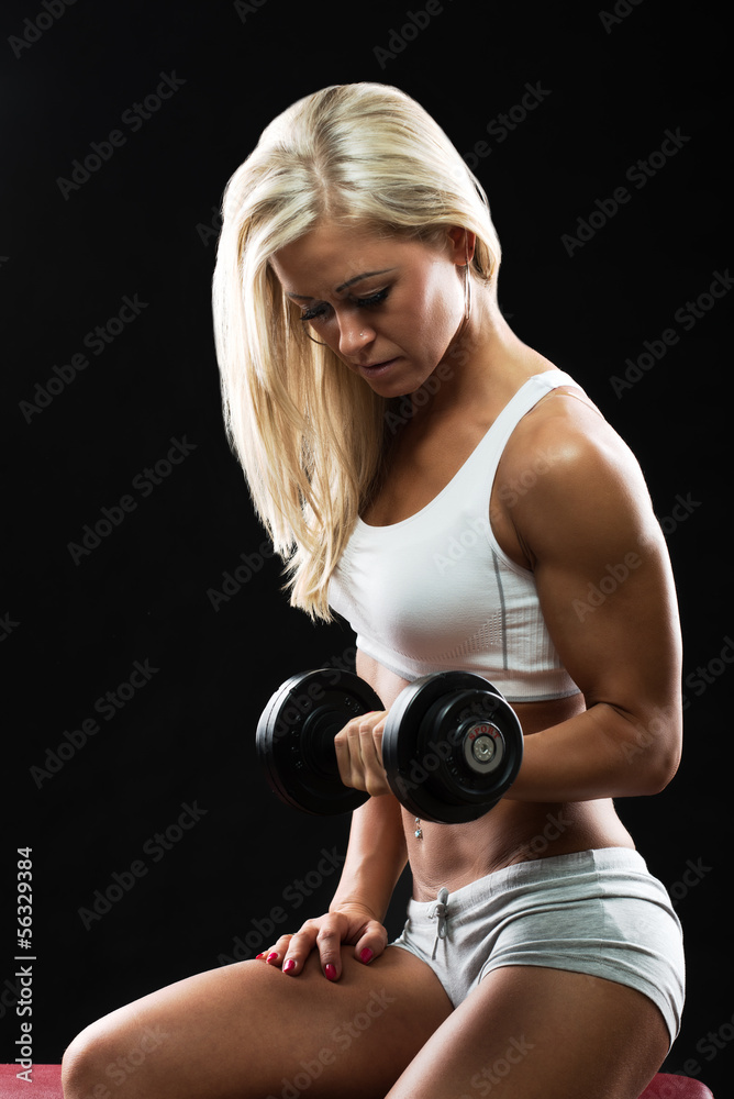 Athletic young woman doing a fitness workout with dumbbell Athletic young woman doing a fitness workout with dumbbell
