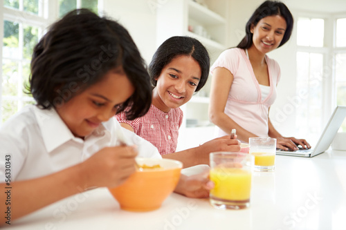 Children Having Breakfast With Mother Before School