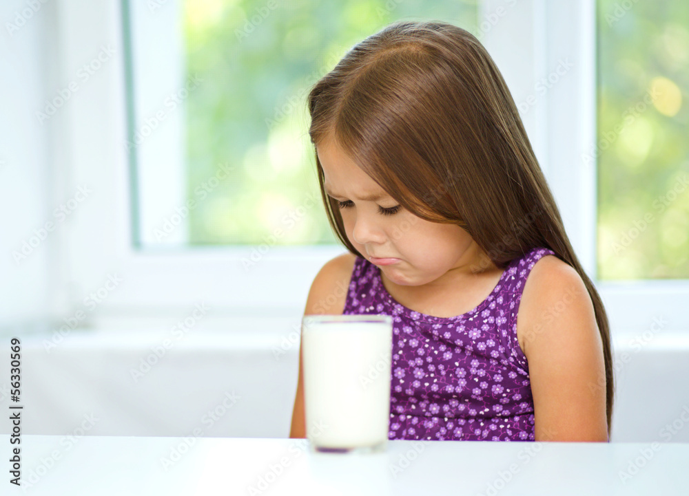 Sad little girl with a glass of milk Sad little girl with a glass of milk