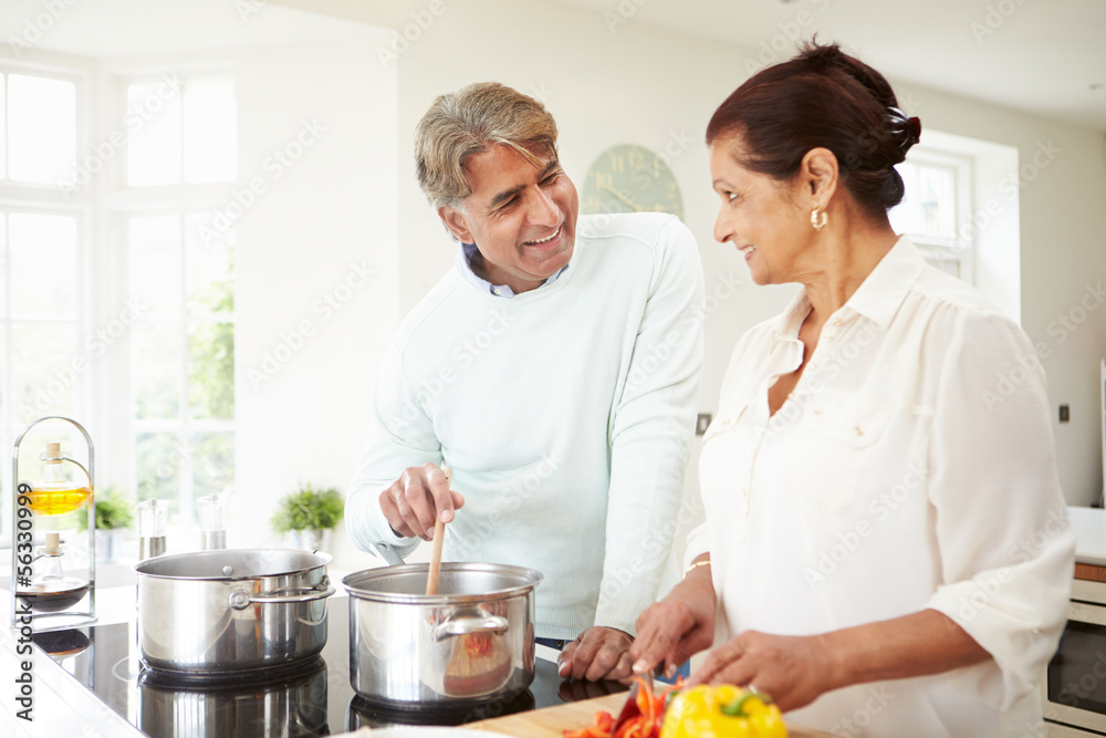 Senior Indian Couple Cooking Meal At Home