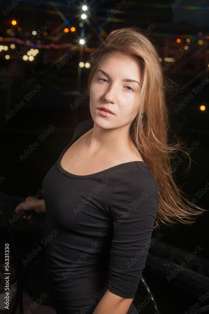 Beautiful lonely woman in the old house against city night Beautiful lonely woman in the old house against city night
