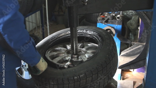 Mechanic removes car tire closeup