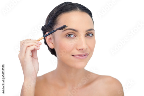 Young brunette using eyebrow brush