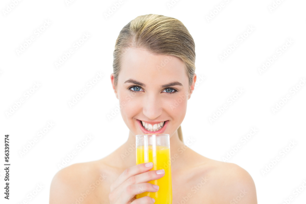 Smiling attractive blonde holding glass of orange juice