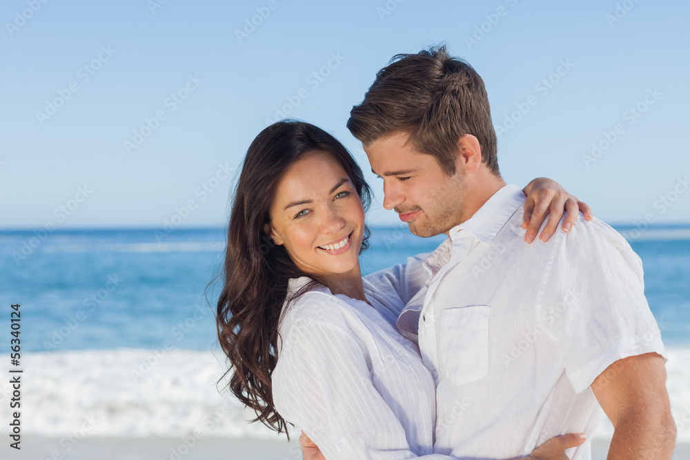 Young couple embracing and posing on the beach