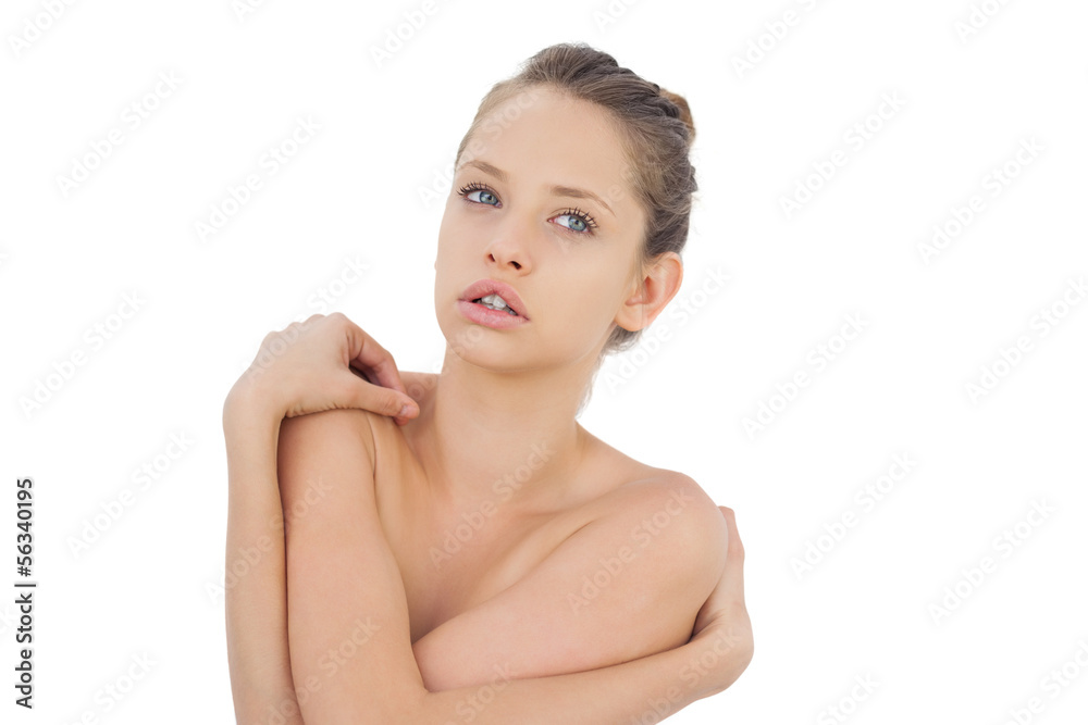Concentrated brunette model posing holding her shoulders Concentrated brunette model posing holding her shoulders