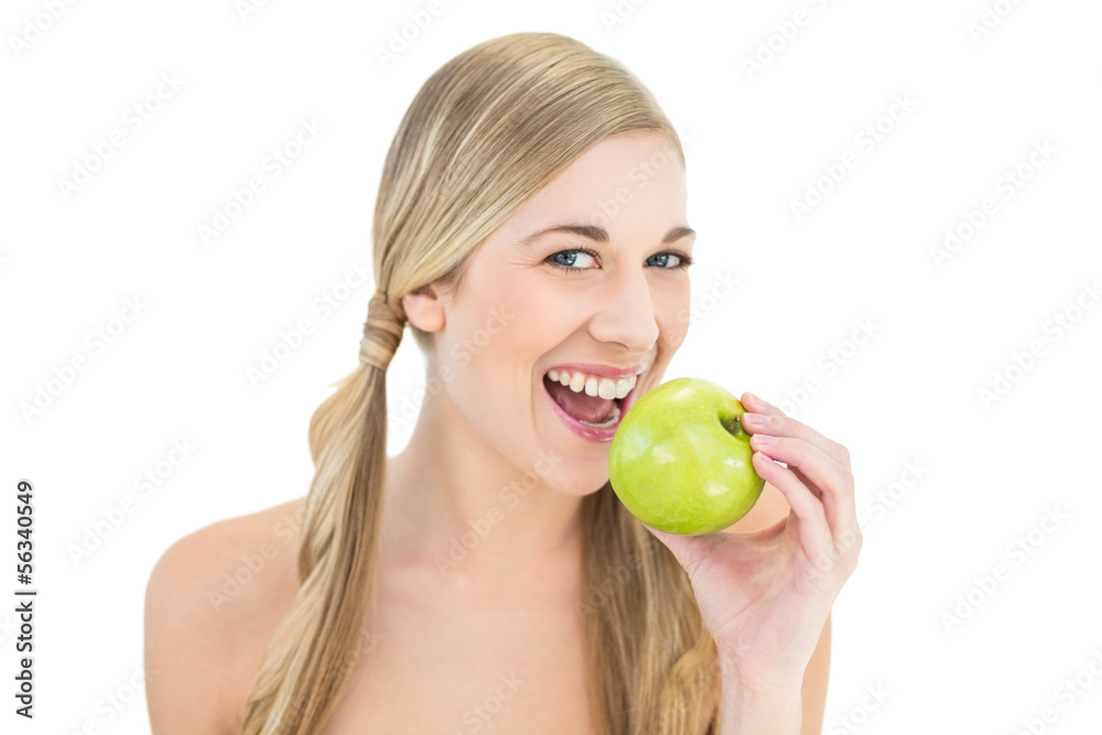 Smiling young blonde woman eating an apple Smiling young blonde woman eating an apple