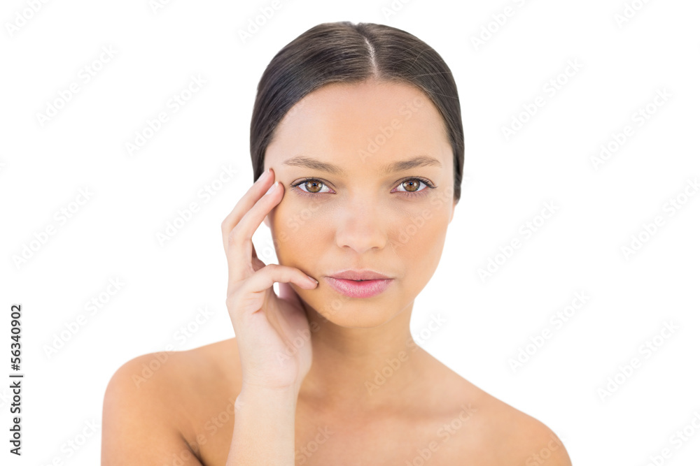 Serious woman holding hand on her face looking at camera