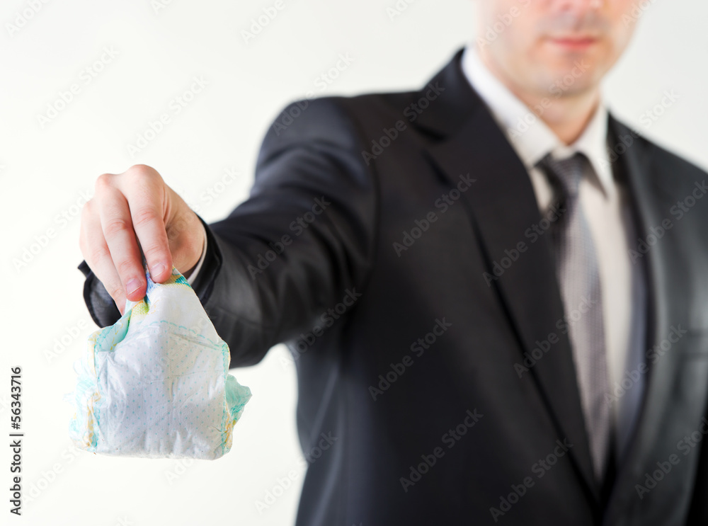 Fototapeta premium Businessman holding a dirty diaper