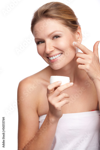 Woman applying cosmetic cream on a clean fresh face