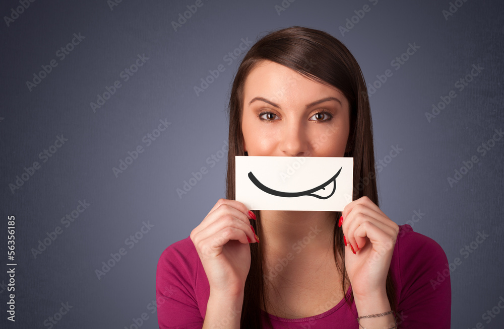 Pretty young girl holding white card with smile drawing Pretty young girl holding white card with smile drawing