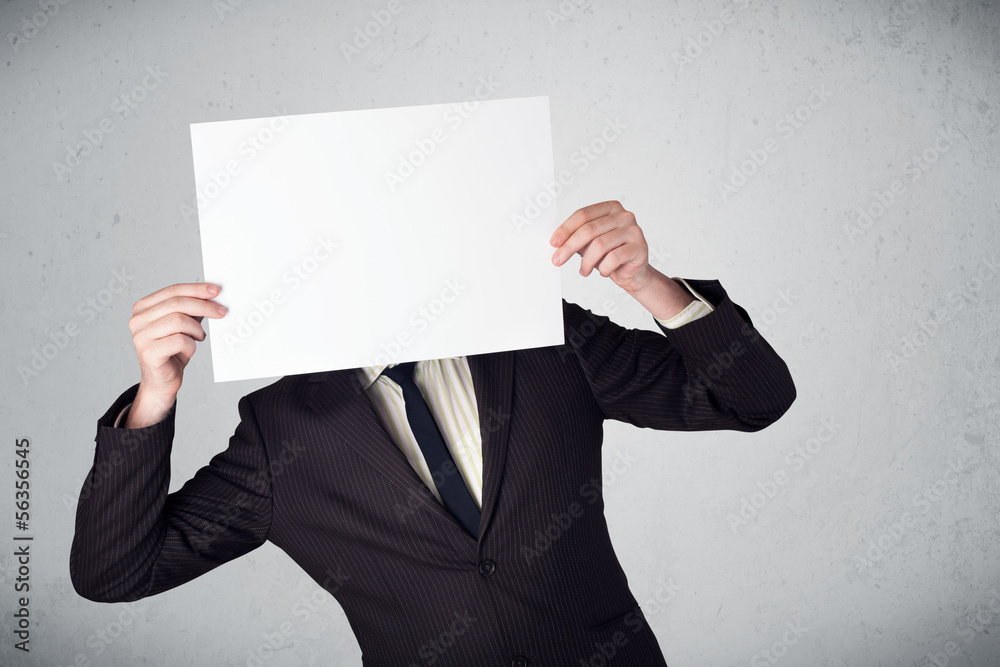 Businessman holding in front of his head a paper with copy space Businessman holding in front of his head a paper with copy space