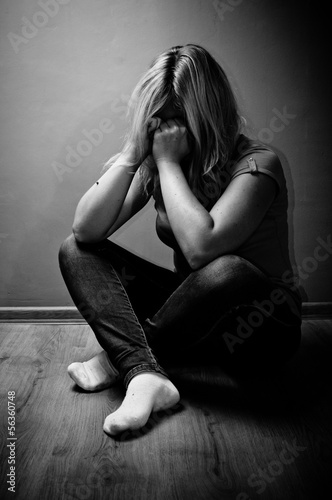 sad woman sitting alone in a empty room © Bartlomiej Zyczynski