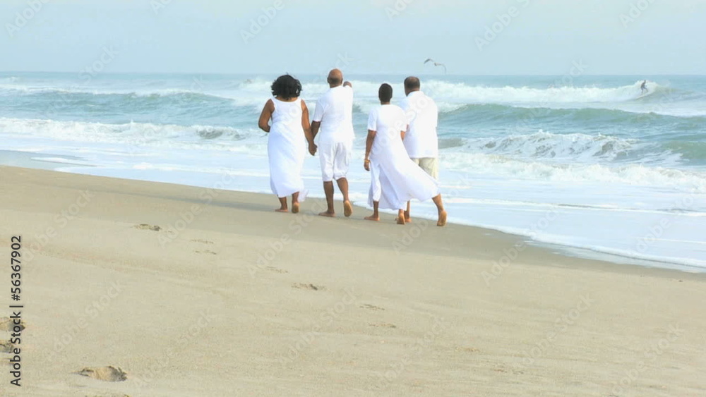 Retired Ethnic Couples Strolling Beside Ocean Retired Ethnic Couples Strolling Beside Ocean