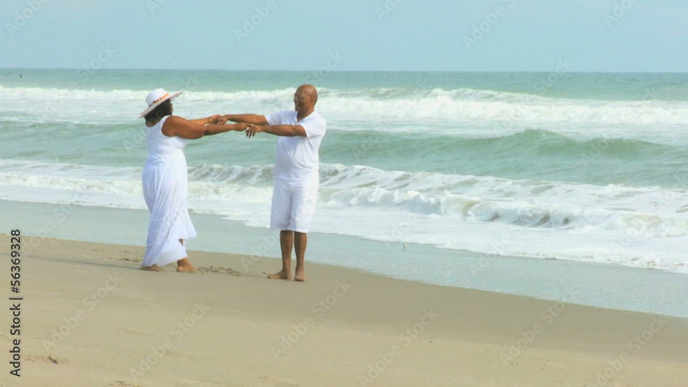 Senior Ethnic Couple Dancing Barefoot on Beach Senior Ethnic Couple Dancing Barefoot on Beach