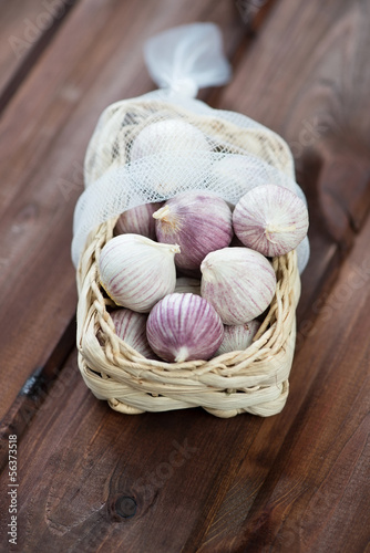 Wicker tray with chinese garlic on rustic wooden background