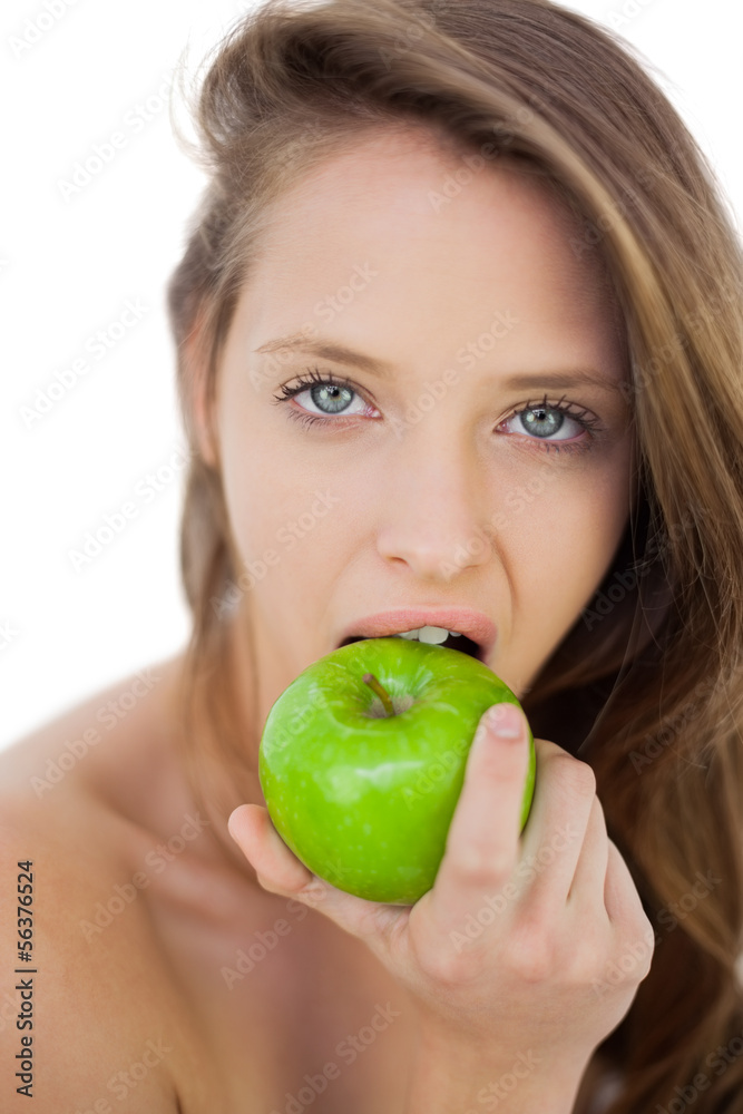 Unsmiling brunette model eating an apple Unsmiling brunette model eating an apple