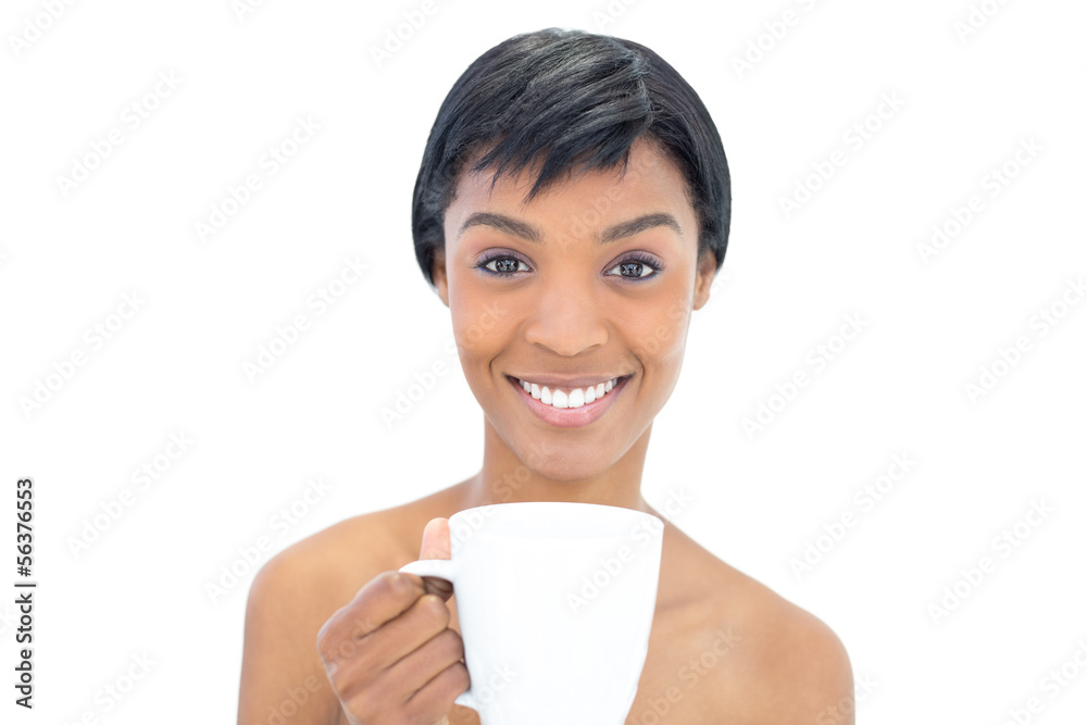 Content black haired woman holding a cup of coffee Content black haired woman holding a cup of coffee