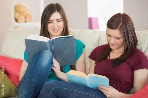 Two girls reading books on the couch