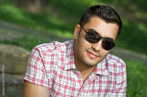 Young cute turkish man in a park, portrait