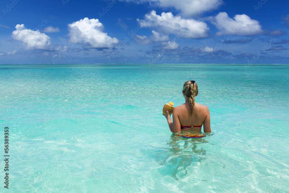 Girl with coconut in the ocean