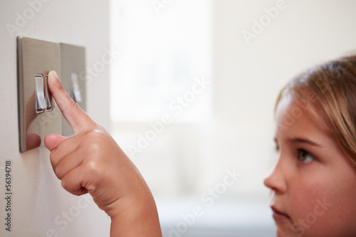 Quadro su tela Young Girl Turning Off Light Switch