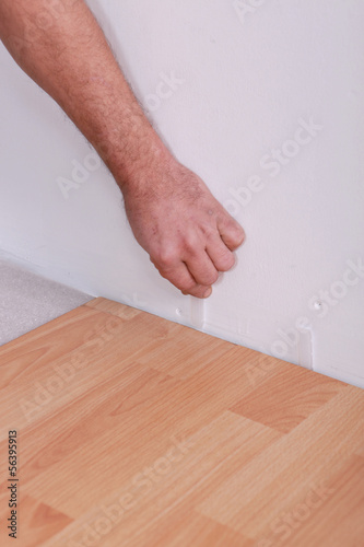 Man using plastic wedges whilst laying parquet