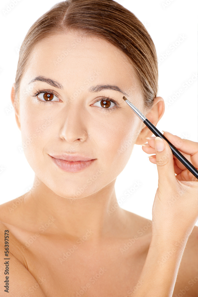 Woman holding a tiny cosmetic brush