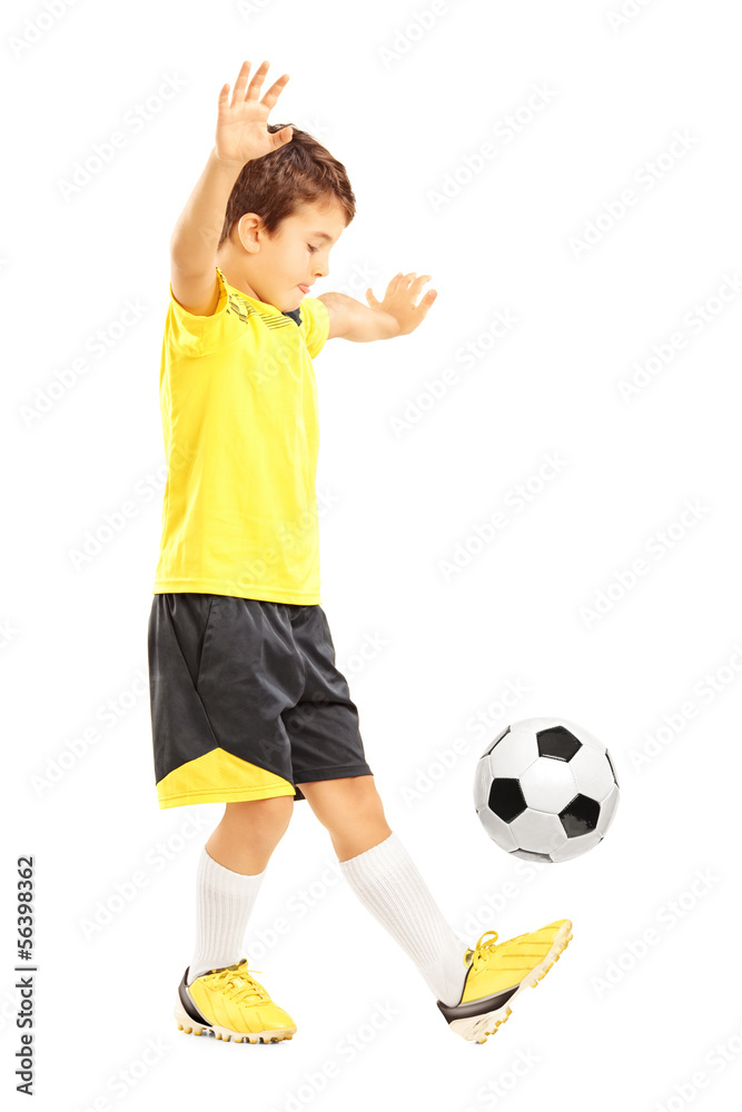 Full length portrait of a boy in sportswear joggling a football