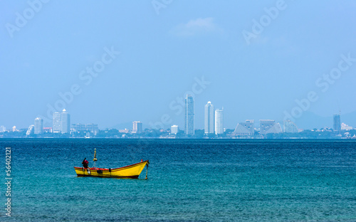 Small fishing boats on the sea and city background