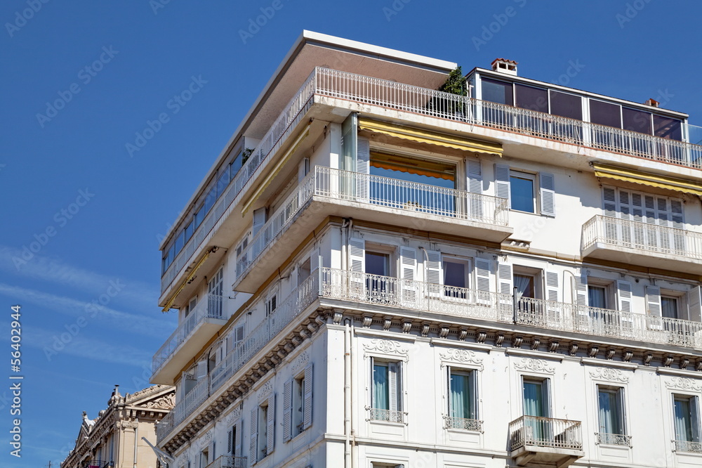 Immeuble blanc avec terrasse, ciel bleu