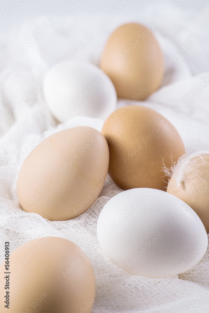 Brown and white eggs on white cloth Brown and white eggs on white cloth