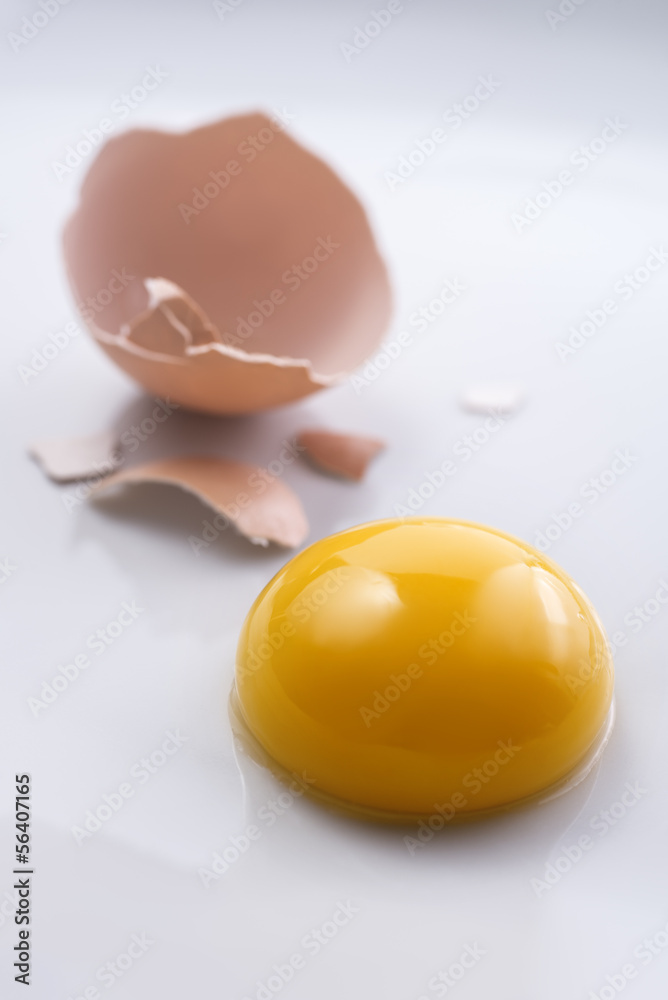 Broken egg and perfect yolk on white background Broken egg and perfect yolk on white background