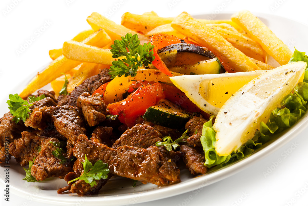 Grilled meat with French fries and vegetables Grilled meat with French fries and vegetables