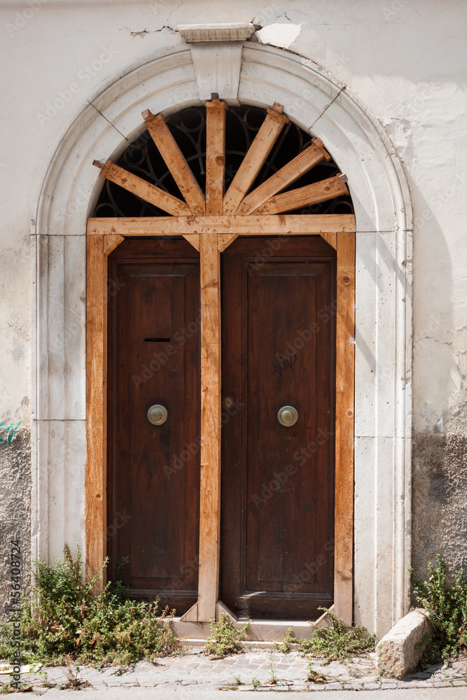 Fototapeta premium Old door shored up with wooden rods