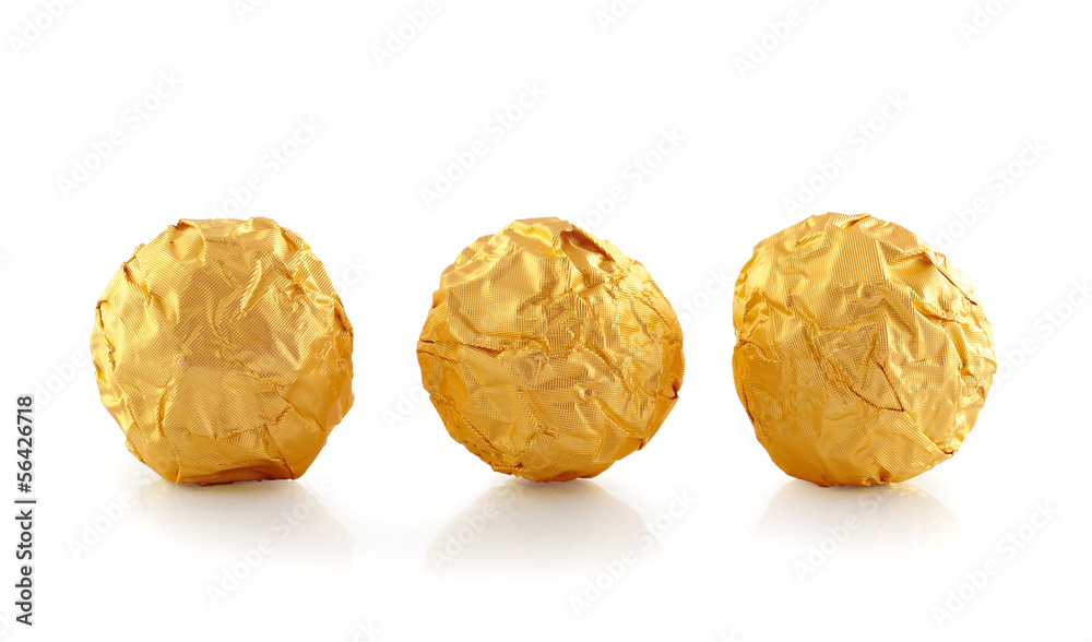 Sweet chocolate candy wrapped in golden foil isolated on white b