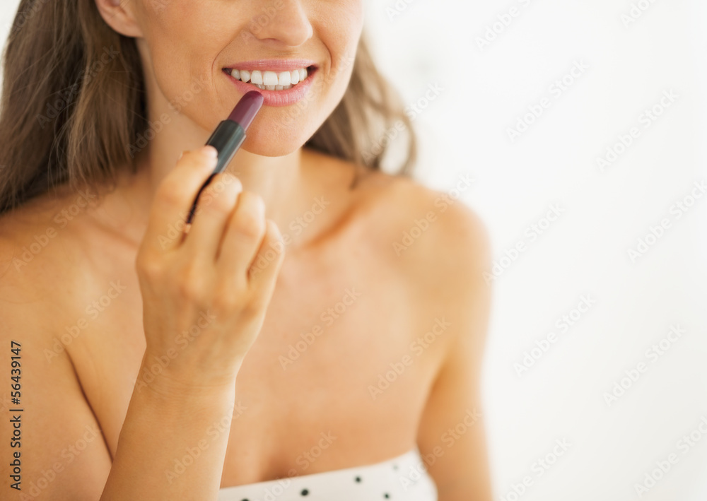 Closeup on woman applying lipstick in bathroom Closeup on woman applying lipstick in bathroom