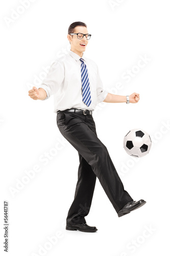 Handsome male with tie and shirt playing with a soccer ball