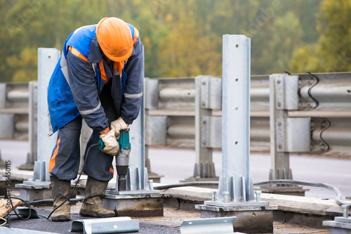 Obraz na plátně Laborer tightening bolts with Electrric Impact Wrench