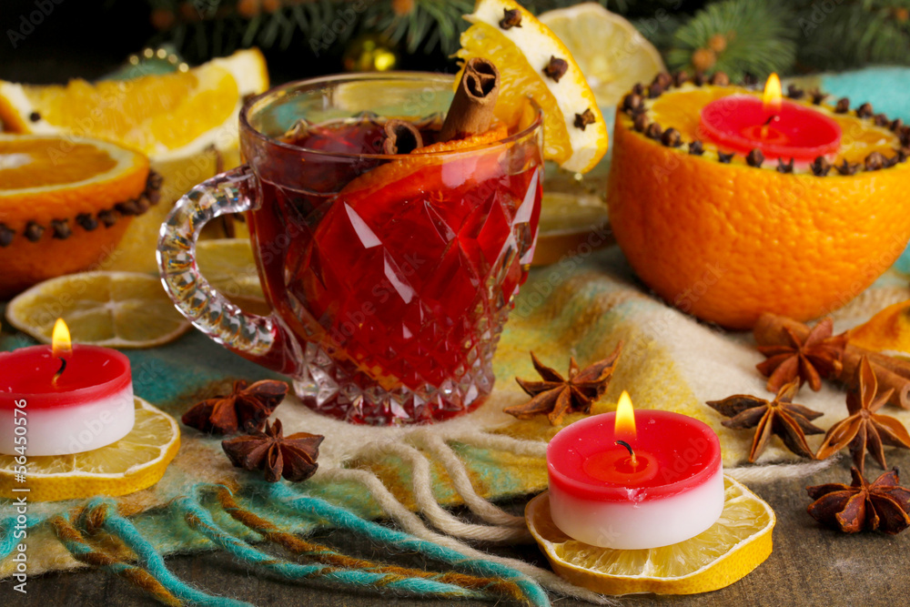 Fragrant mulled wine in glass with spices and oranges around