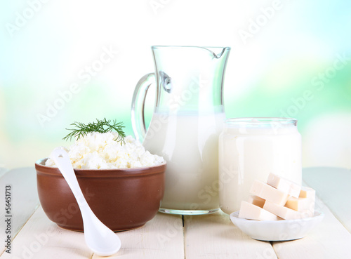 Fresh dairy products on wooden table on natural background