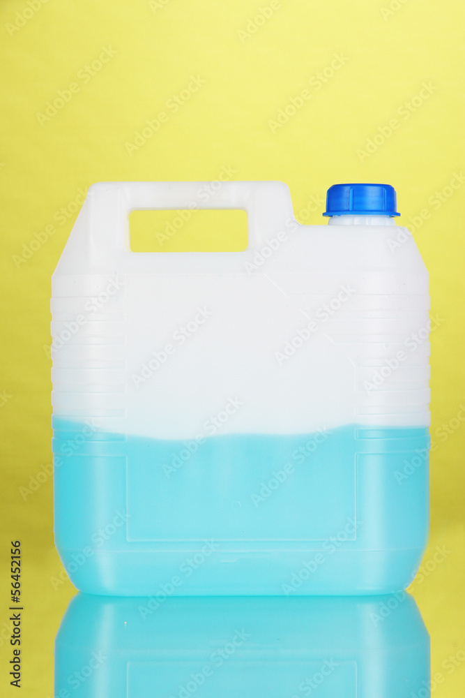 Blue liquid for car in canister on green background